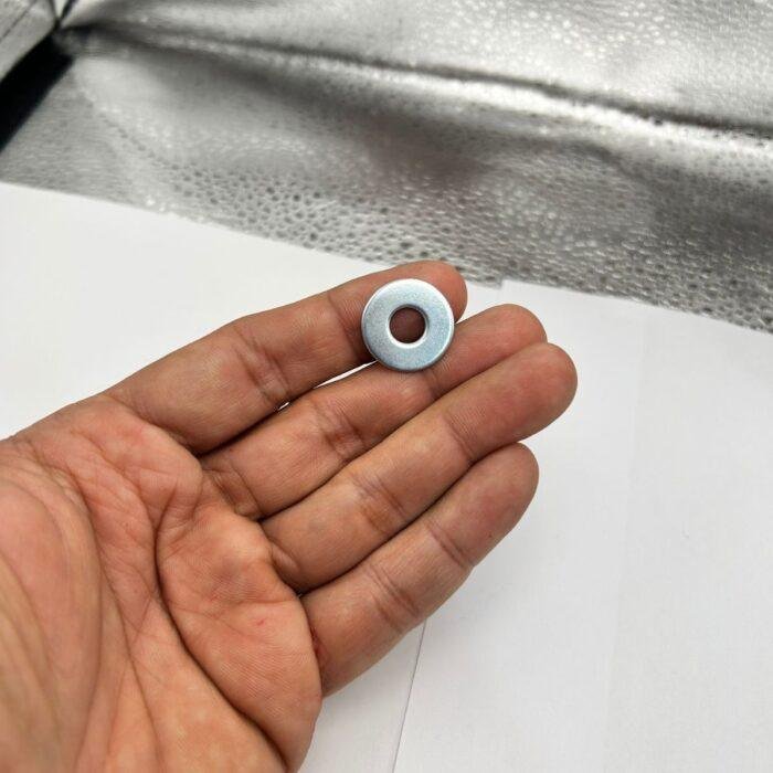 Imagem de uma arruela lisa 1/4 zincada, em aço carbono.